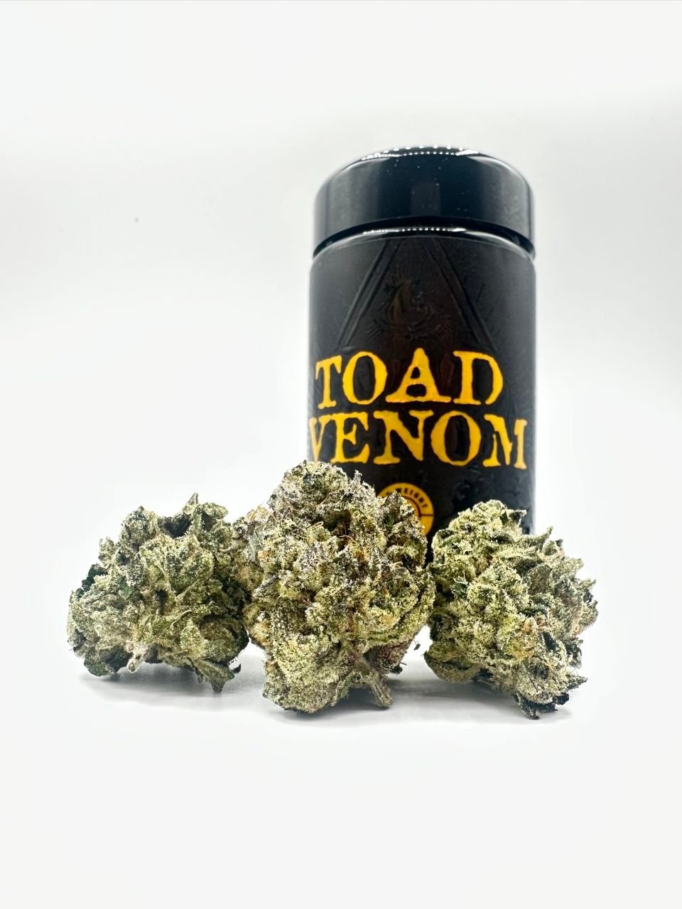 Dense frosty green cannabis nugs of TOAD VENOM by HALL OF FLAME in front of the branded jar