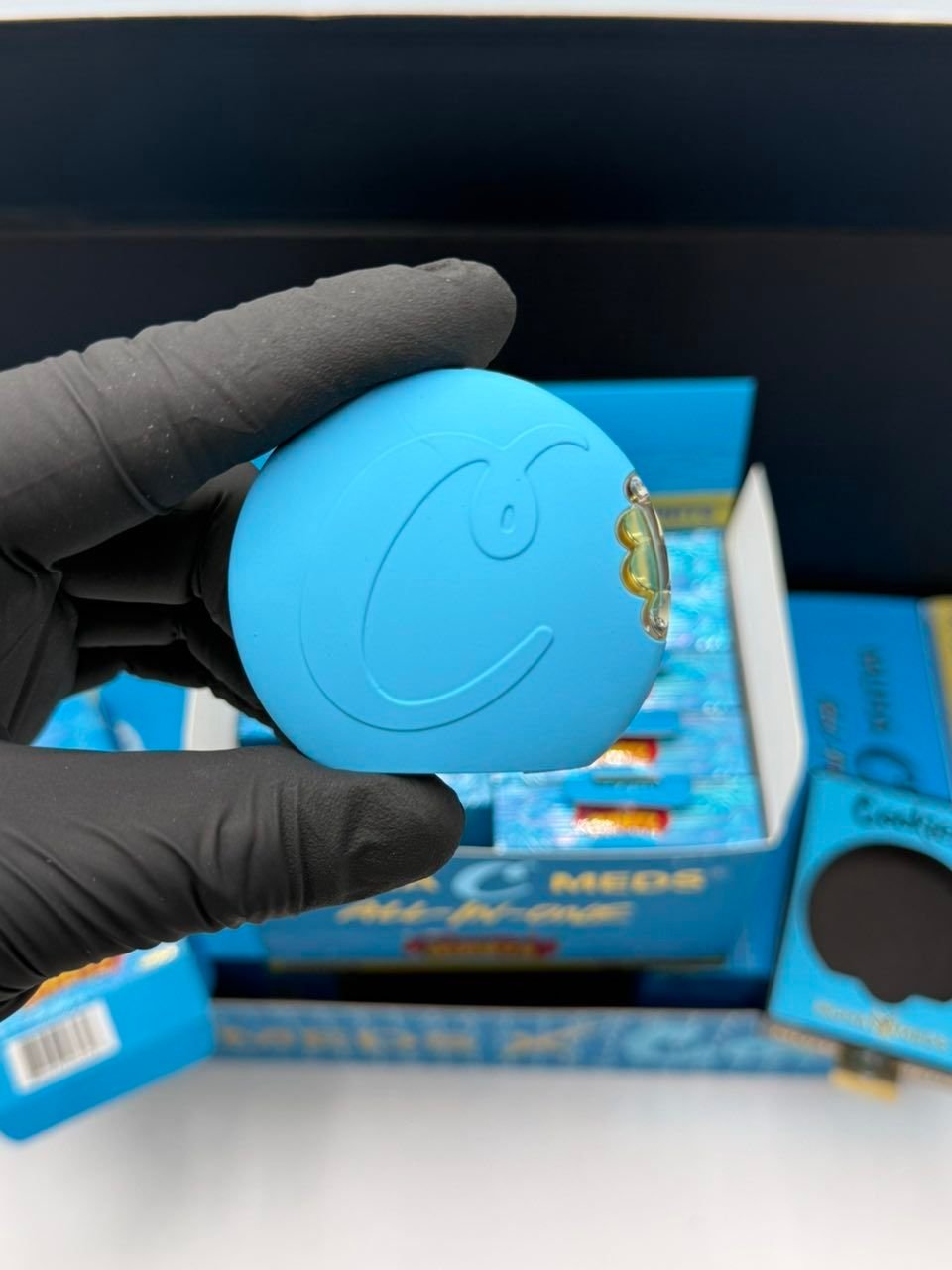 Cookies Muha Meds Vapes blue device with Cookies C logo held in glove