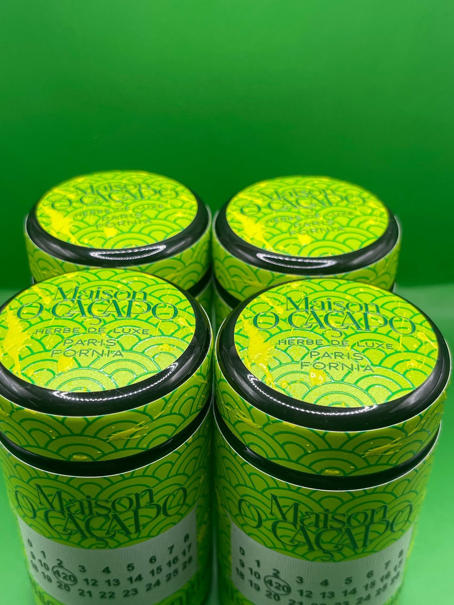 LEMON GIELA by MAISON O CACAPO four designer jars top view with Paris Fornia Herbe De Luxe branding on green wave pattern lids